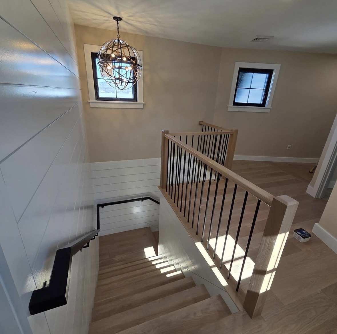 Freshly painted staircase with white shiplap and warm beige walls by Costa Painting Pro