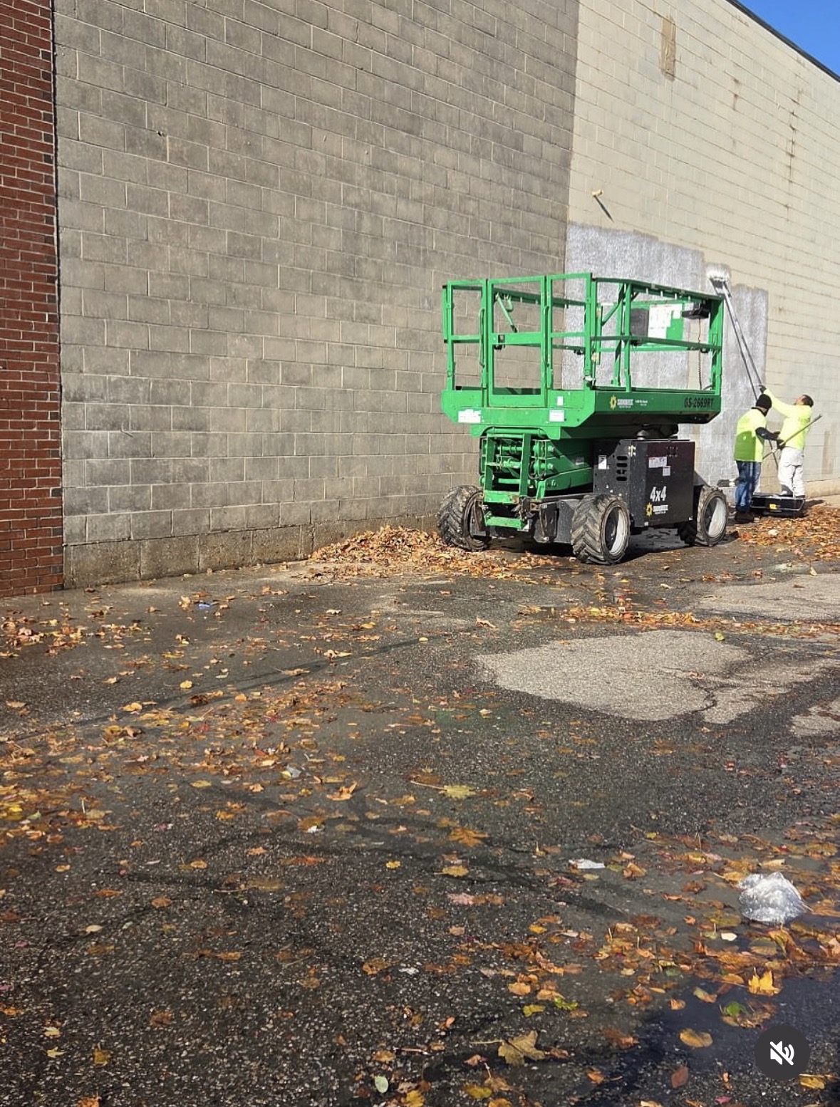 Costa Painting Pro crew prepping a large commercial block wall from a scissor lift